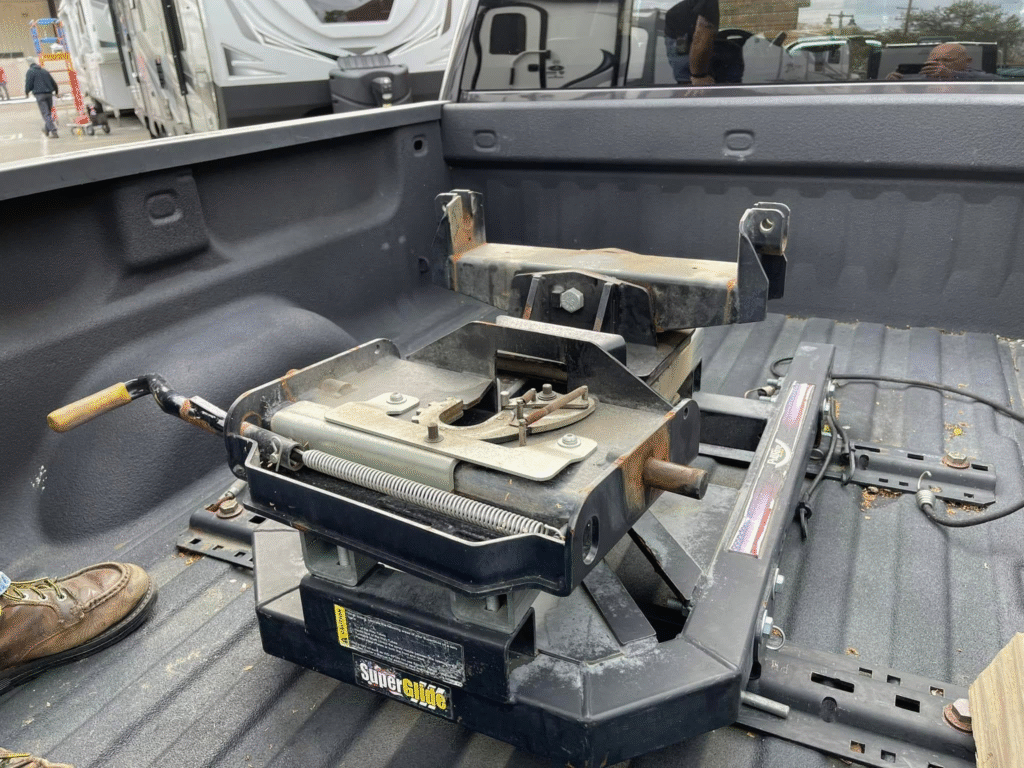 image - California RV Specialists Pickup bed with a heavy-duty SuperGlide trailer hitch mounted, showing rails, levers, and mounting brackets in use.