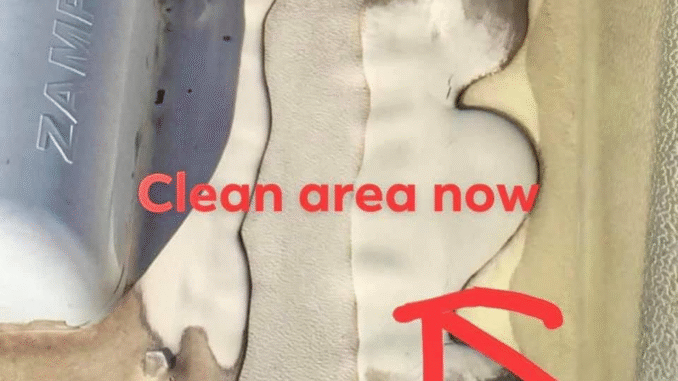 Close-up of a seam on a metal surface with beige sealant; a red arrow points to the area labeled 'Clean area now'.