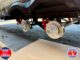 RV undergoing brake maintenance with wheels removed, showing exposed brake rotors and wheel hubs undercarriage on stands